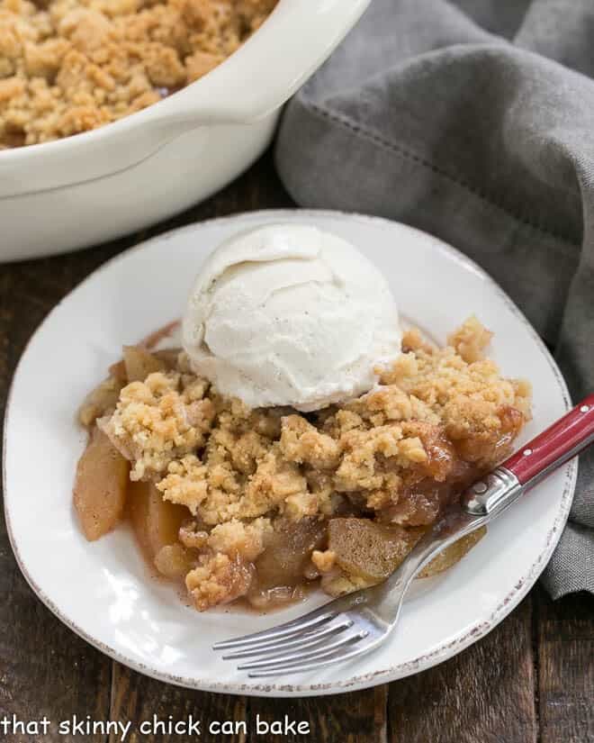 Easy Apple Crisp on a white plate topped with ice cream.