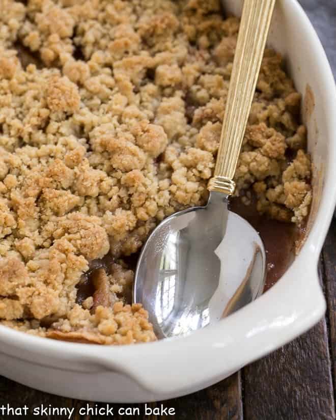 Easy Apple Crisp in a white ceramic baking dish with a serving spoon