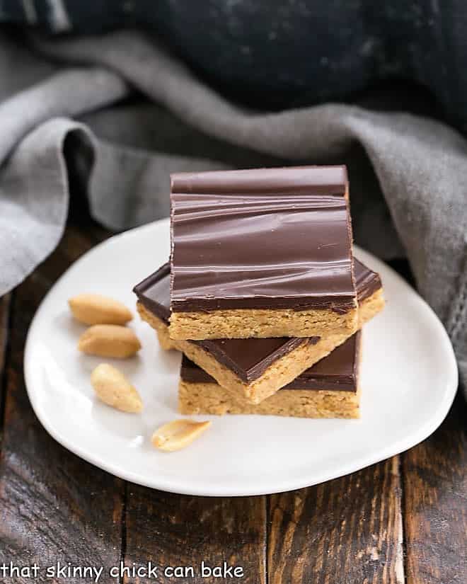 3 Homemade Reese's Bars stacked on a white egg shaped plate.