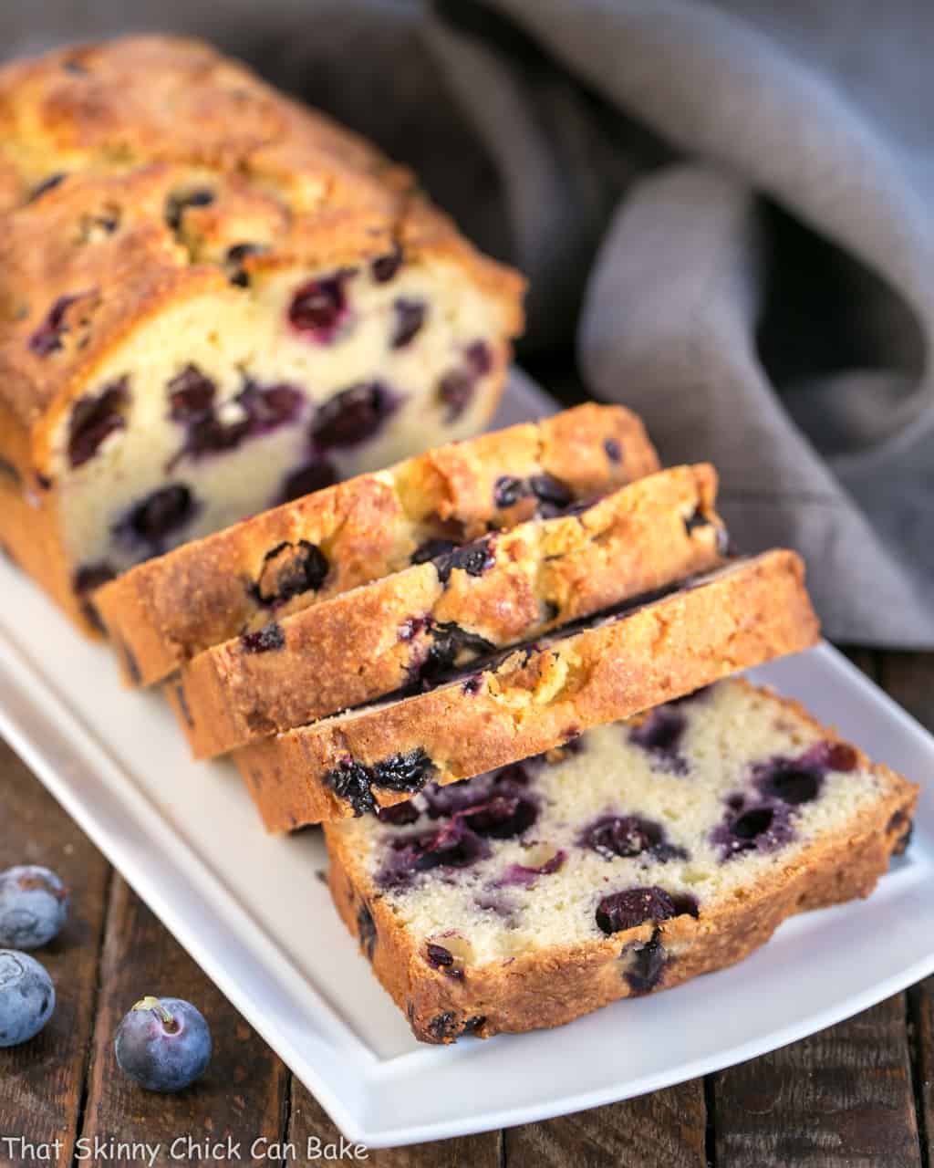 Sliced Lemon Blueberry Muffin Bread on a white serving tray.