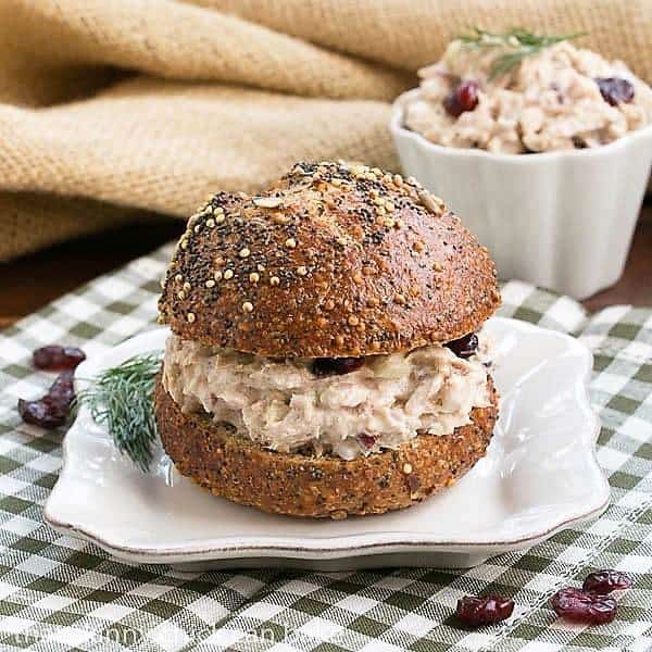 Tuna salad on a bun on a square white plate