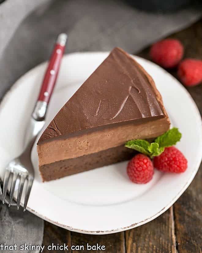 Frozen Chocolate Mousse Cake on a white plate with raspberry garnish