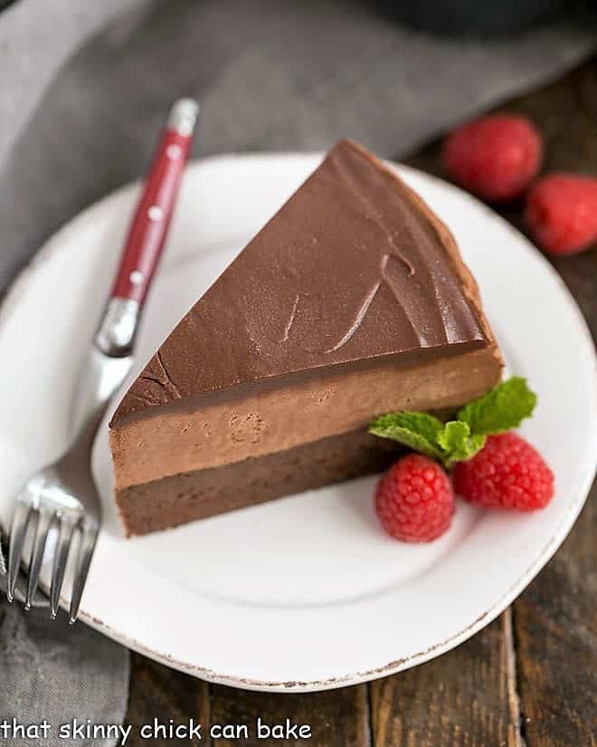 Frozen Chocolate Mousse Cake on a white plate with raspberry garnish.