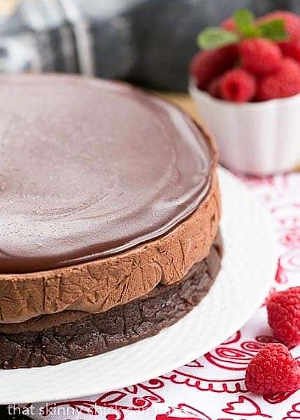 Frozen Chocolate Mousse Cake on a white cake plate on a red and white napkin