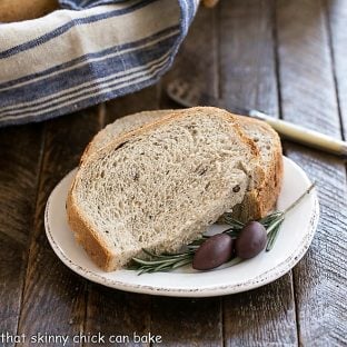 Sliced Rosemary Olive Bread on a small, white ceramic plate