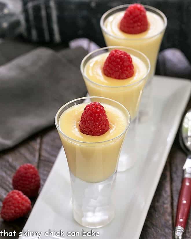 3 cordial glasses filled with white chocolate pudding with Frangelico and topped with a fresh raspberry.