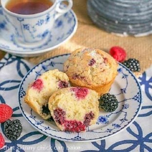 Double Berry Muffins on a blue and white plate with a cup of tea