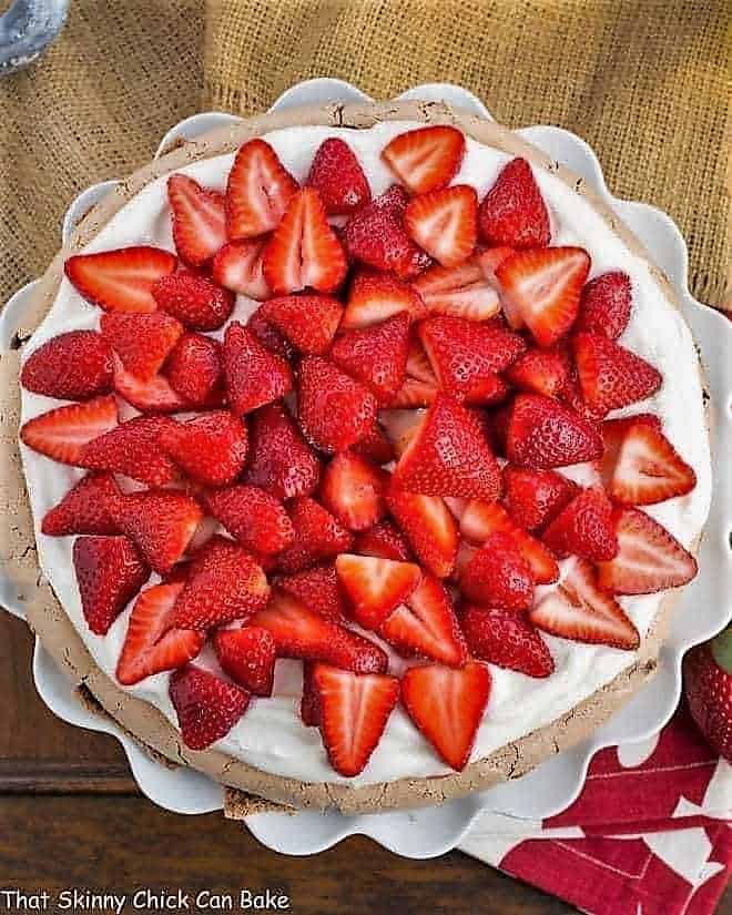 Strawberry Topped Chocolate Pavlova overhead shot on a ruffled white cake plate