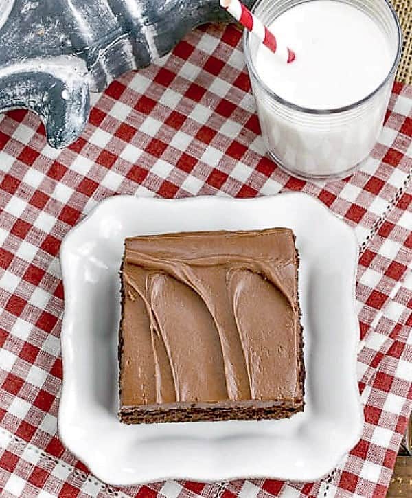 Cocoa Fudge Cake on a white dessert plate with a glass of milk.