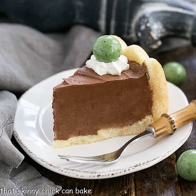 Irish Chocolate Mousse Cake slice on a white ceramic plate with a garnish of whipped cream and a green candy