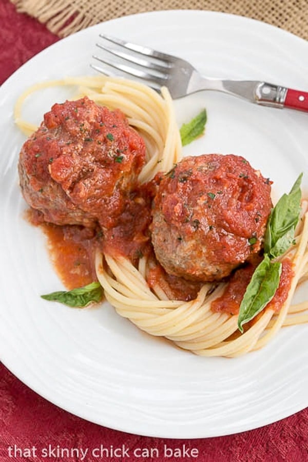 Mozzarella Stuffed Meatballs with pasta on a white plate.