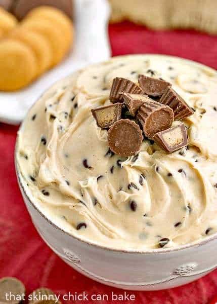 Tagalong Dip in a white serving bowl topped with mini Reese's peanut butter cups