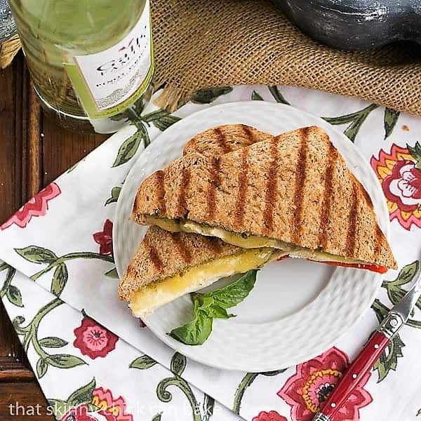 Chicken Pesto Grilled Cheese view from above on a white plate with a basil garnish and a red handled fork.