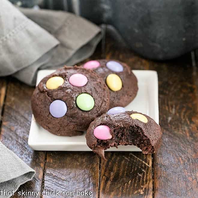 3 Brownie Cookies on a square white plate, one with a bite removed