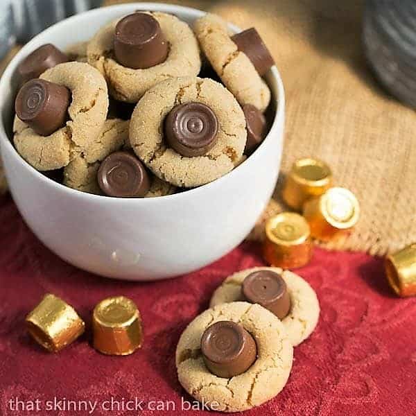 Rolo Peanut Blossoms in a white bowl with two cookies on the side.