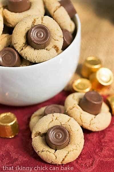 Rolo Peanut Blossoms in a white bowl with a few candies and cookies on the side.