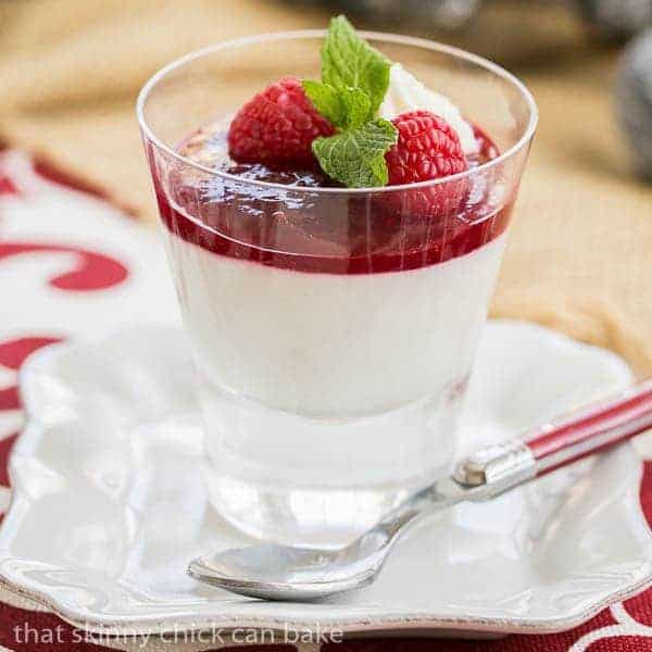 Raspberry White Chocolate Cheesecake Parfaits in a clear glass topped with raspberries and mint