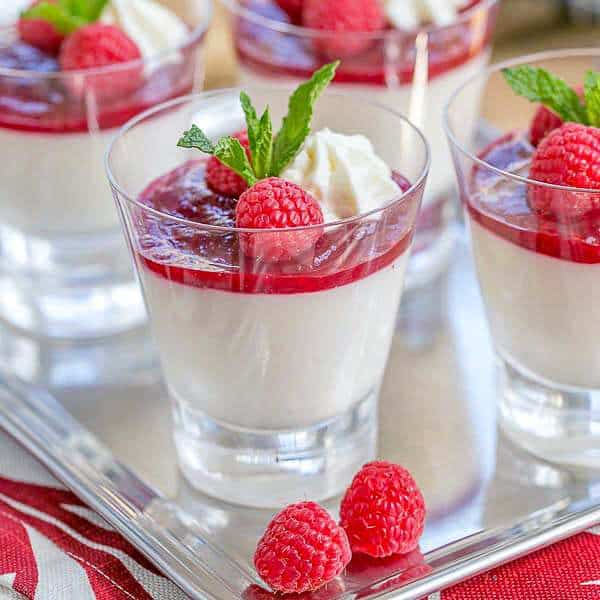Close view ofRaspberry White Chocolate Cheesecake Parfaits on a silver tray