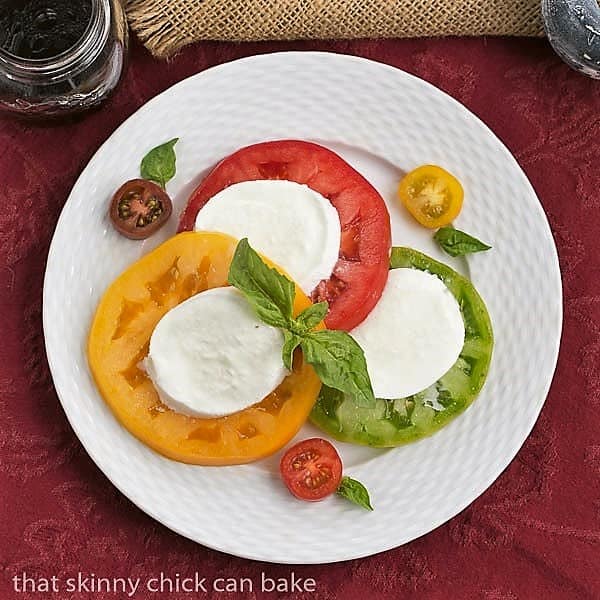 Overhead view Salade de Tomates et Fromage on a white basketweave plate