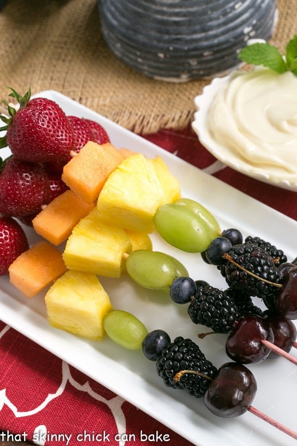 Fruit Kebabs with White Chocolate Mascarpone Dip on a rectangular white ceramic tray.