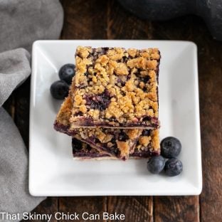 stack of blueberry streusel bars on a white ceramic plate