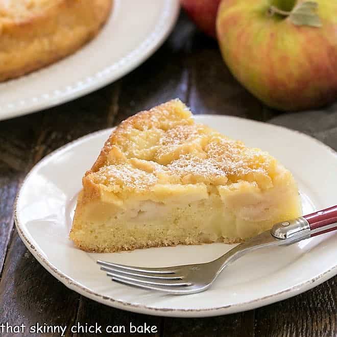 A slice of apple cake on a round white plate.