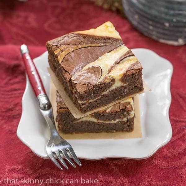 2 Ricotta Cheesecake Brownies on a square white plate with a fork.