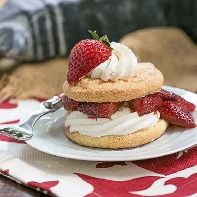 Strawberry Shortcake Franco American Style on a white dessert plate topped with roasted berries and cream