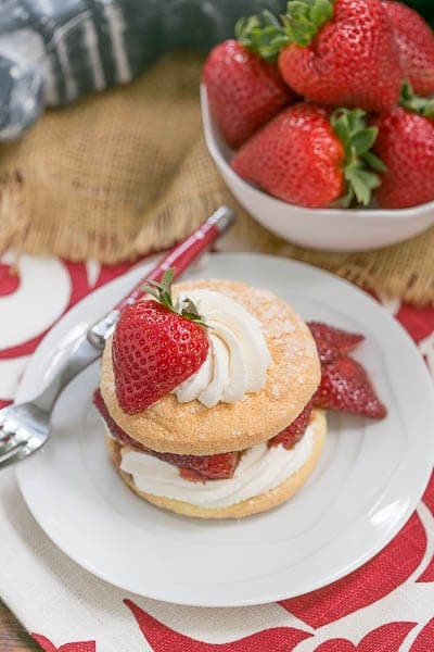 Strawberry Shortcake Franco American Style on a white plate with a bowl of fresh strawberries