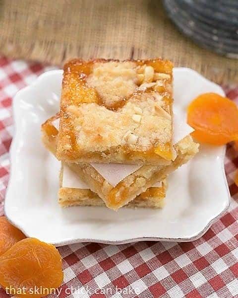 Coconut Apricot Bars with dried apricot garnishes on a small square plate.