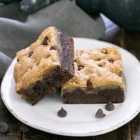 Two brookies stacked on a round white plate with chocolate chips