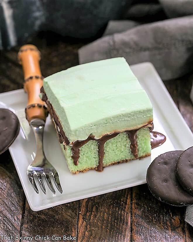 Slice of Creme de Menthe cake on a square white plate with a bamboo fork
