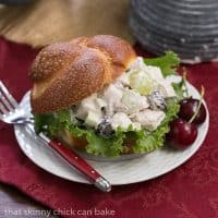A plate of  chicken salad on a bun over a red napkin