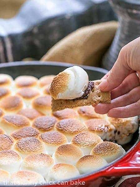 Skillet S'mores Dip with a bite scooped up on a graham cracker