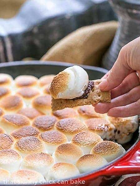 Skillet S'mores Dip with a bite scooped up on a graham cracker.
