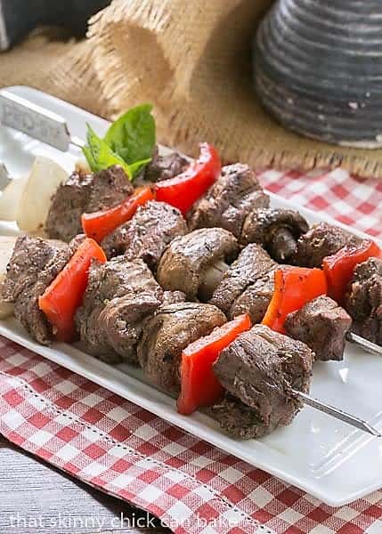 Skewered Grilled Beef Steak Kabobs with vegetables on a white tray