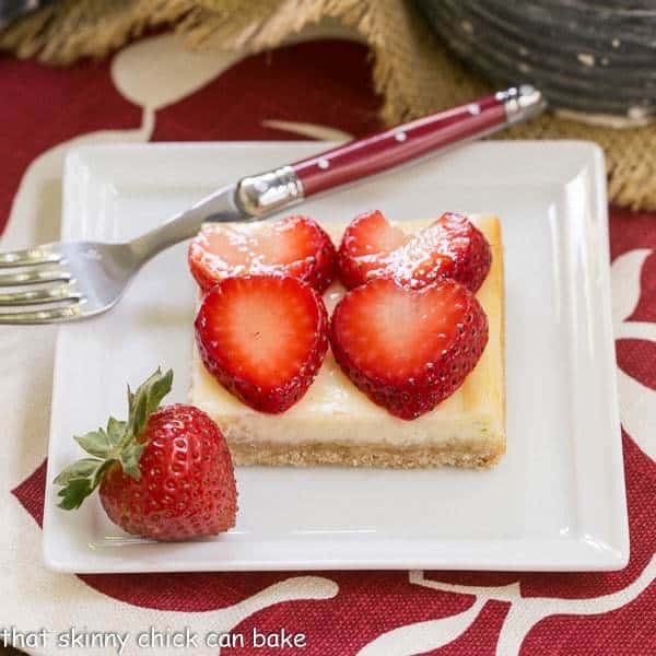 Strawberry Cheesecake Bars | A shortbread cookie crust topped with a thin layer of cheesecake and juicy sliced berries