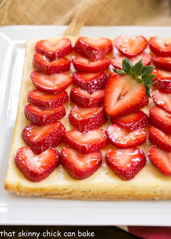 Close view of Strawberry Cheesecake Bars on a white ceramic platter.