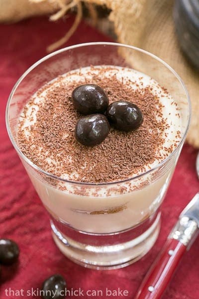 Classic Tiramisu in a cocktail glass garnished with chocolate covered coffee beans.