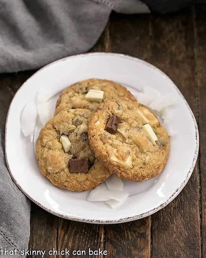 Chewy Oatmeal Toffee Cookies with a coconut bonus - fabulous flavors and textures in every bite make for truly irresistible cookies! 3 Chewy Oatmeal Toffee Cookies on a round white dessert plate.