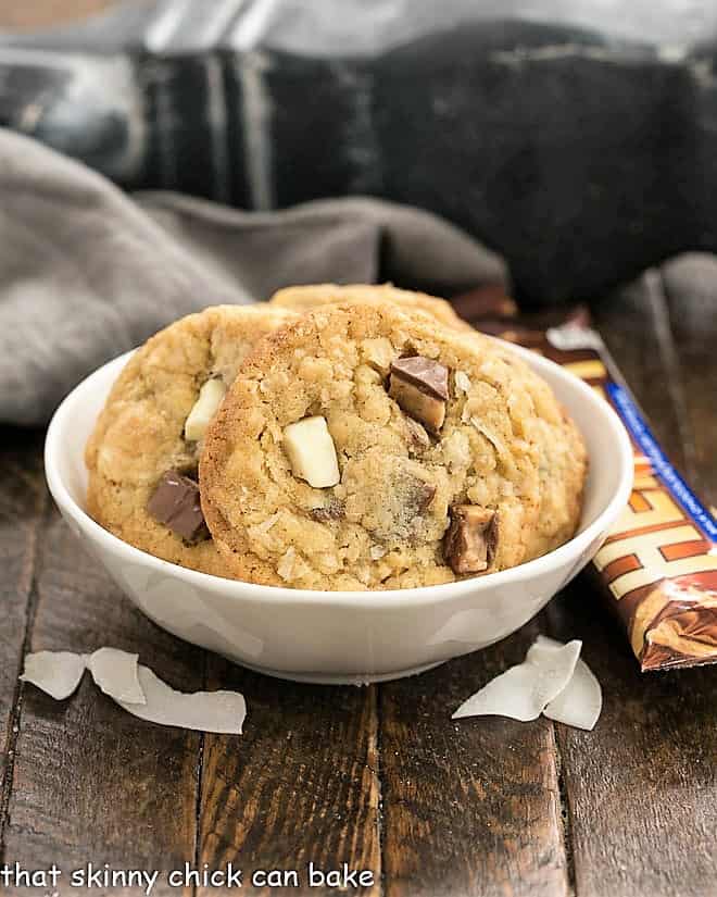 Chewy Oatmeal Toffee Cookies in a white bowl with coconut flakes and Heath bars.