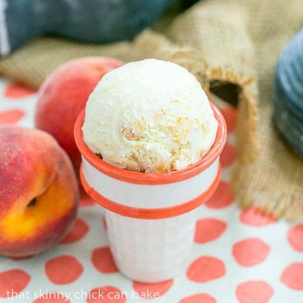Fresh Peach iice cream scoops in an orange trimmed ceramic ice cream cone.