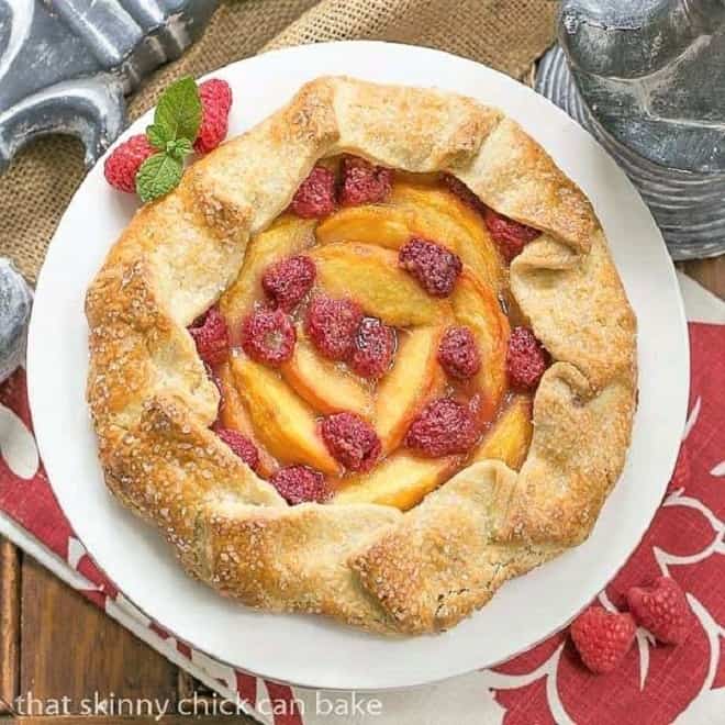 Overhead view of aPeach Raspberry Galette on a white ceramic cake stand.