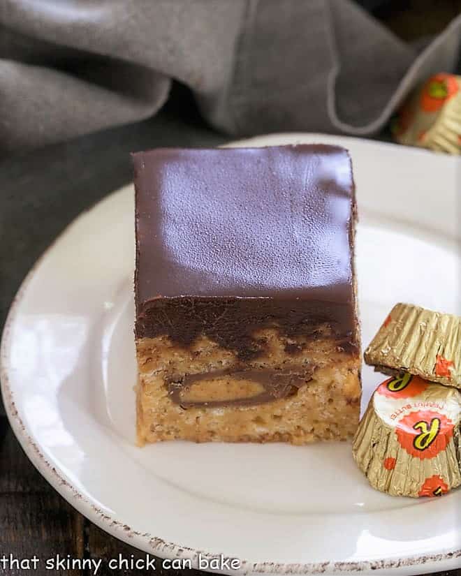 One  Peanut Butter Rice Krispie Treat on a round white plate with 2 mini Reeses 