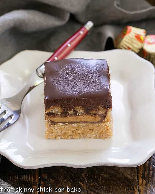 Stuffed Peanut Butter Rice Krispie Treats on a square white plate with a red handle fork