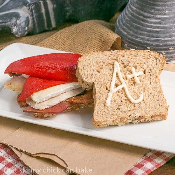 Roasted Chicken Brie and Bacon Sandwich on a white tray.