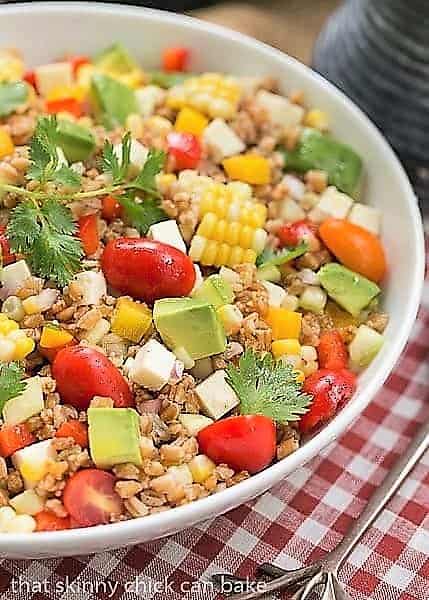 Summer Farro Salad in a white bowl over a checked napkin