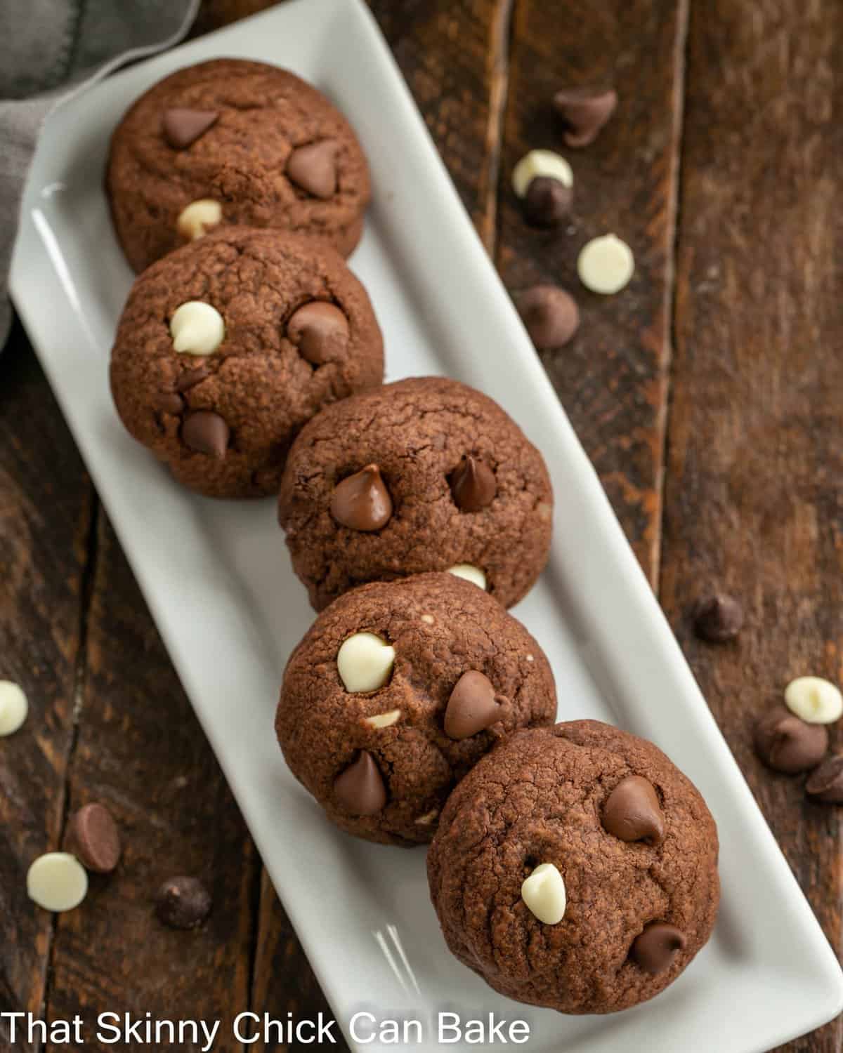 Overhead view of chocolate chocolate cookies on a narrow white ceramic tray.