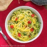 Zucchini Noodles with Parmesan in a white bowl on a red napkin