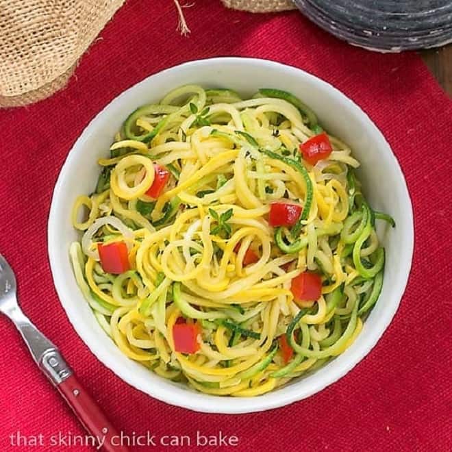 Zucchini Noodles with Parmesan in a white bowl on a red napkin.